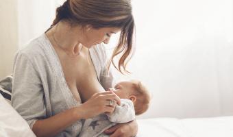 Mutter stillt ihr Baby, Stillen schützt vor Asthma